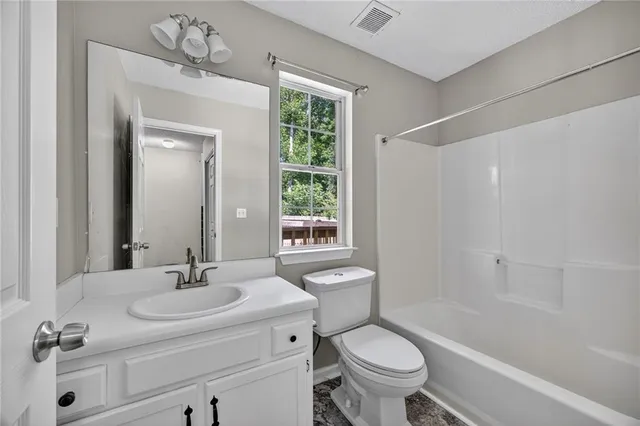 a bathroom with a sink toilet a mirror and shower