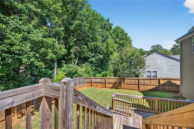 a view of a wooden deck and a backyard