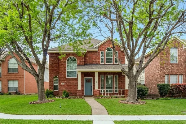 front view of a brick house with a yard