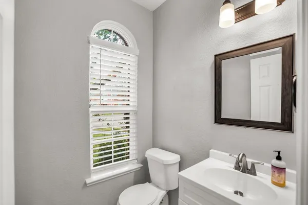 a bathroom with a toilet a sink and mirror