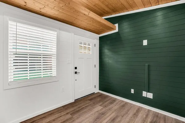 a view of a small space with wooden floor and a window