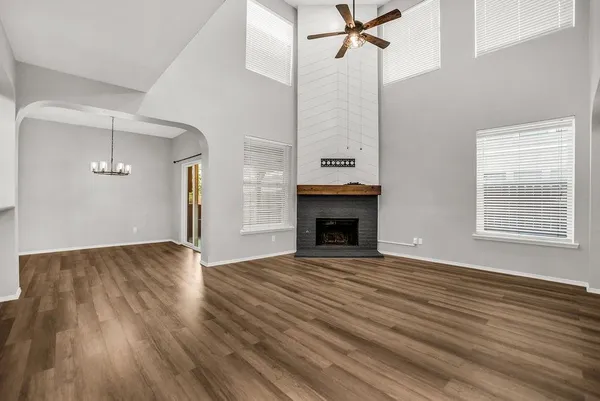 a view of empty room with wooden floor and fireplace