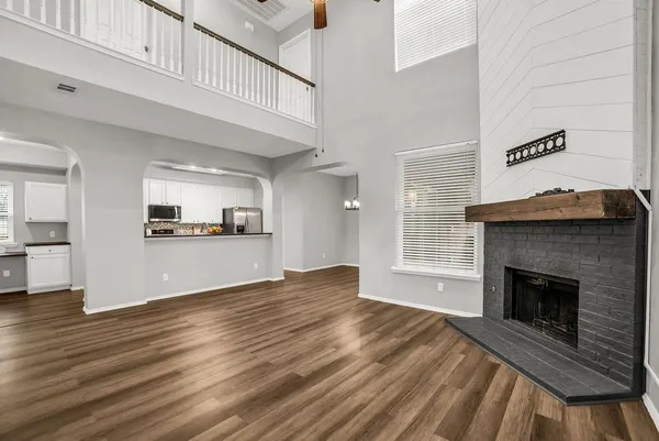 a view of empty room with wooden floor and fireplace