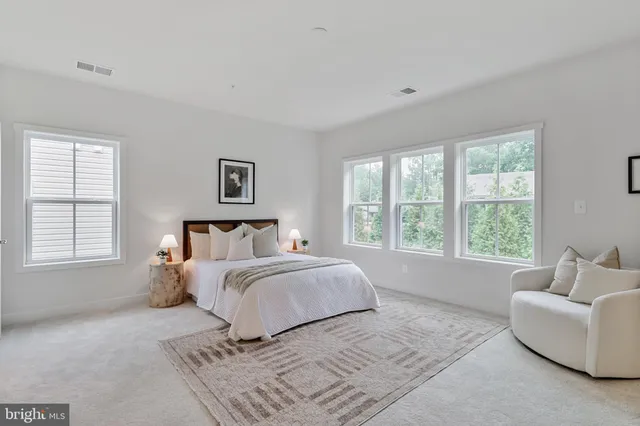 a spacious bedroom with a bed and a couch with window