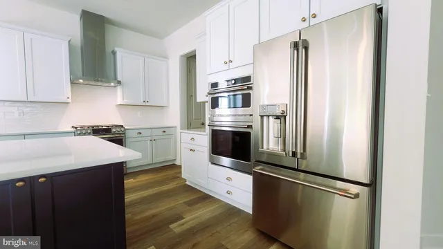 a kitchen with stainless steel appliances granite countertop a refrigerator a stove and a sink