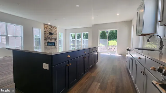 a kitchen with stainless steel appliances granite countertop lots of counter top space and wooden floor