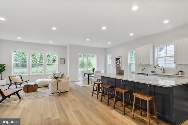 a living room with stainless steel appliances granite countertop furniture dining table and a large window