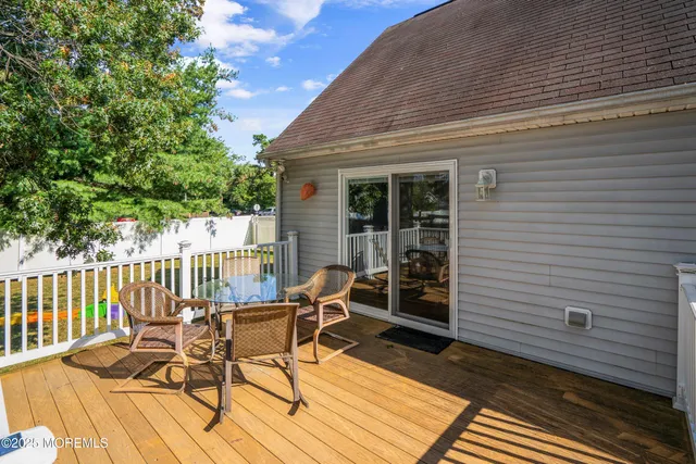 a view of a roof deck with table and chairs and wooden floor