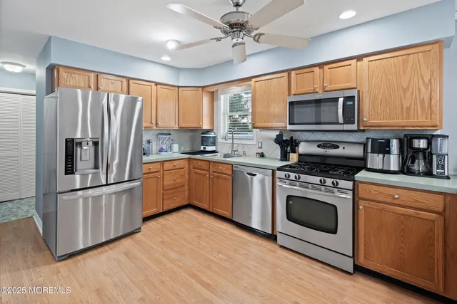 a kitchen with stainless steel appliances granite countertop a stove a sink dishwasher a refrigerator and a microwave oven with cabinets