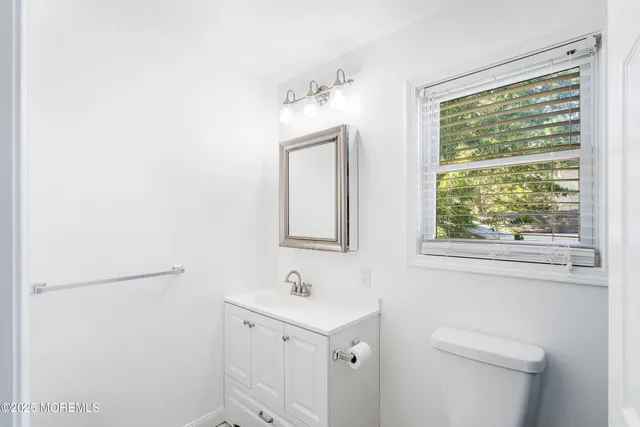 a bathroom with a sink a toilet and a window