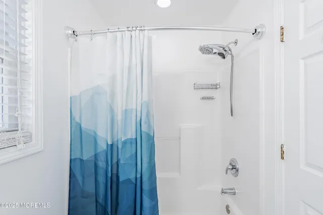 a bathroom with a shower and a glass door