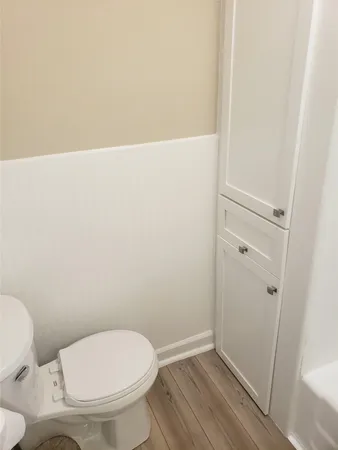 a white toilet sitting next to a shower