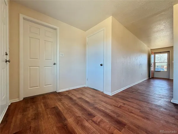 a view of empty room with window and wooden floor