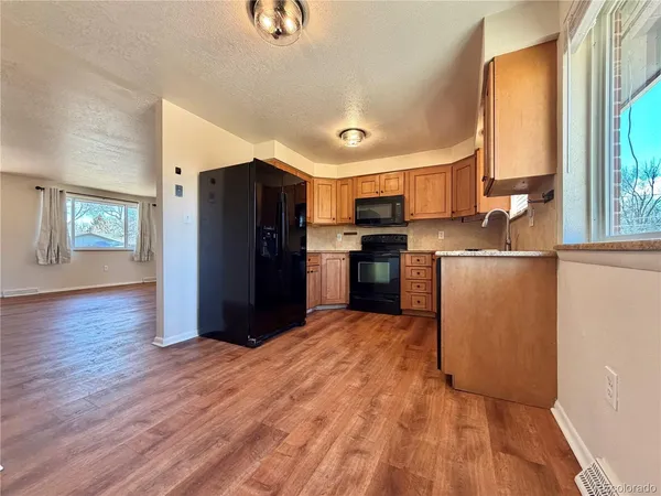 a kitchen with stainless steel appliances granite countertop a refrigerator and a stove top oven