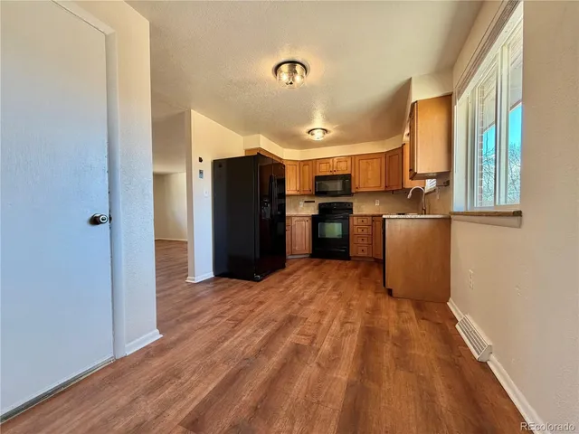 a view of a kitchen with a refrigerator a sink and dishwasher a refrigerator with wooden floor