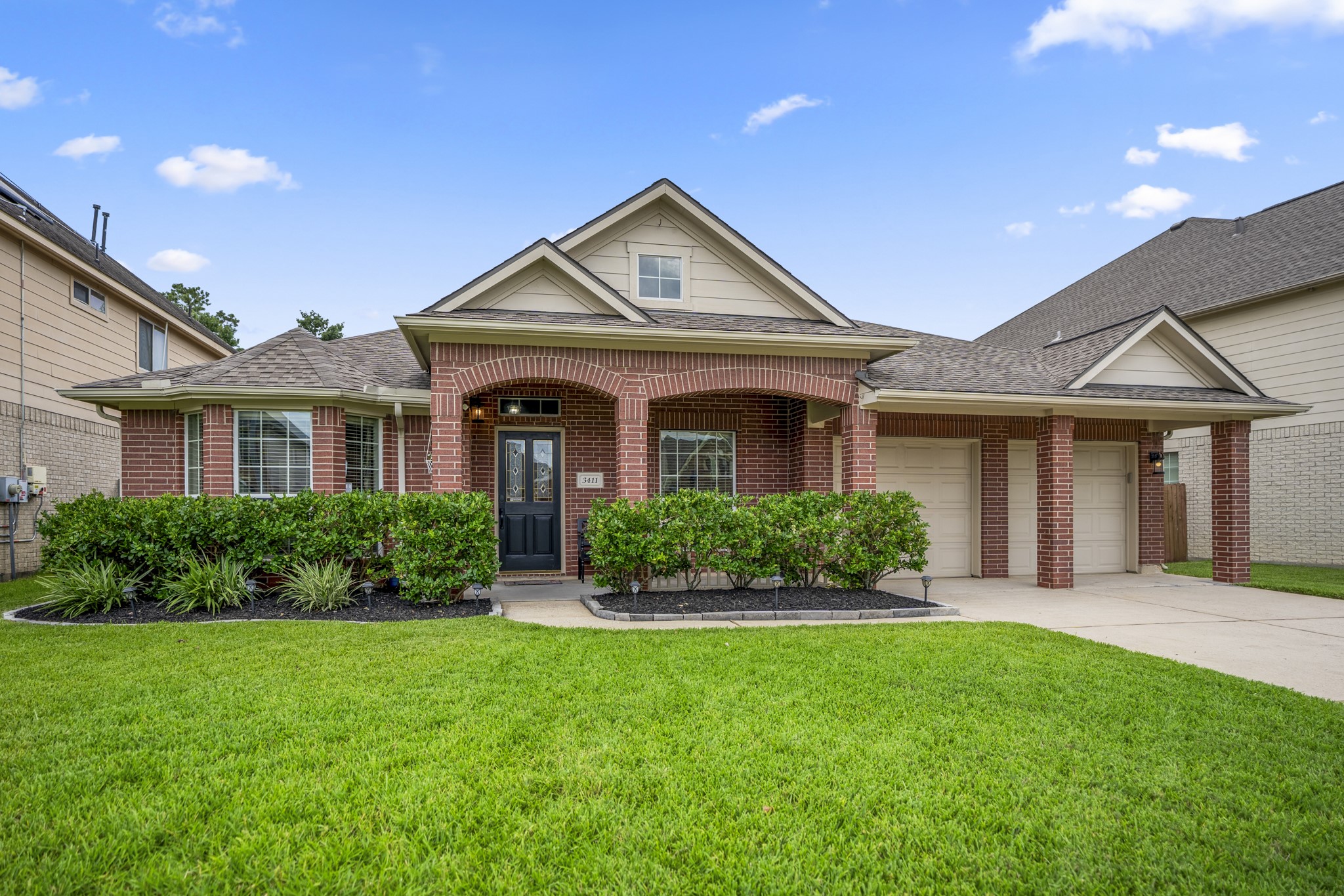 3411 Utah Beach Court Spring, TX 77388 - Photo 2 of 50 Closer to the entry, the covered front porch gives the home a welcoming place to pause before stepping inside. The bay window on the left brings natural light into the front living area, while the split garage doors and double-wide driveway keep the front elevation balanced and functional for a nearly 3,000 sq ft one-story layout.