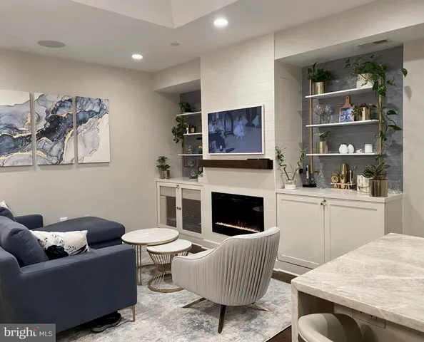 a living room with furniture a flat screen tv and a fireplace