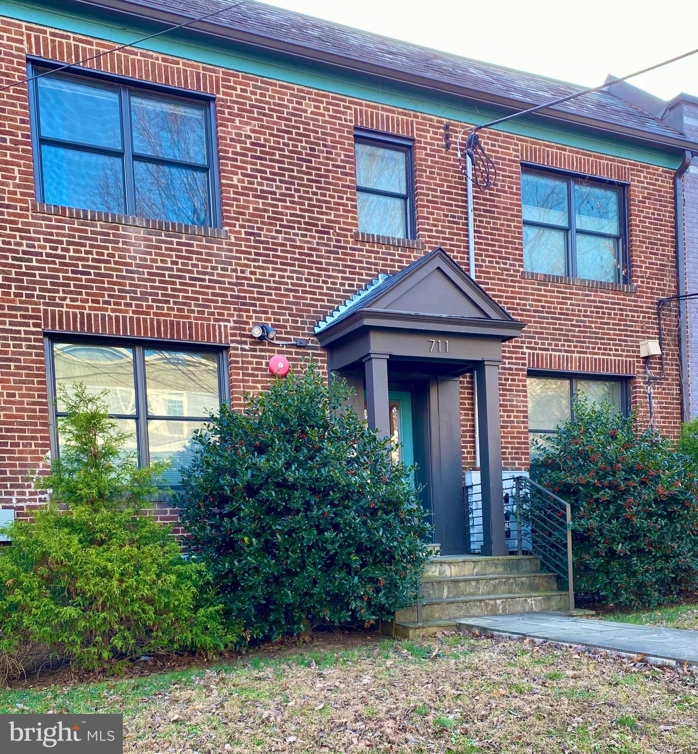 711 Jackson Street Northeast, Unit 3 Washington, DC 20017 - Photo 16 of 17 a view of a brick house with plants and large tree