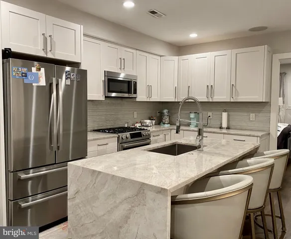 a kitchen with a sink a refrigerator and cabinets