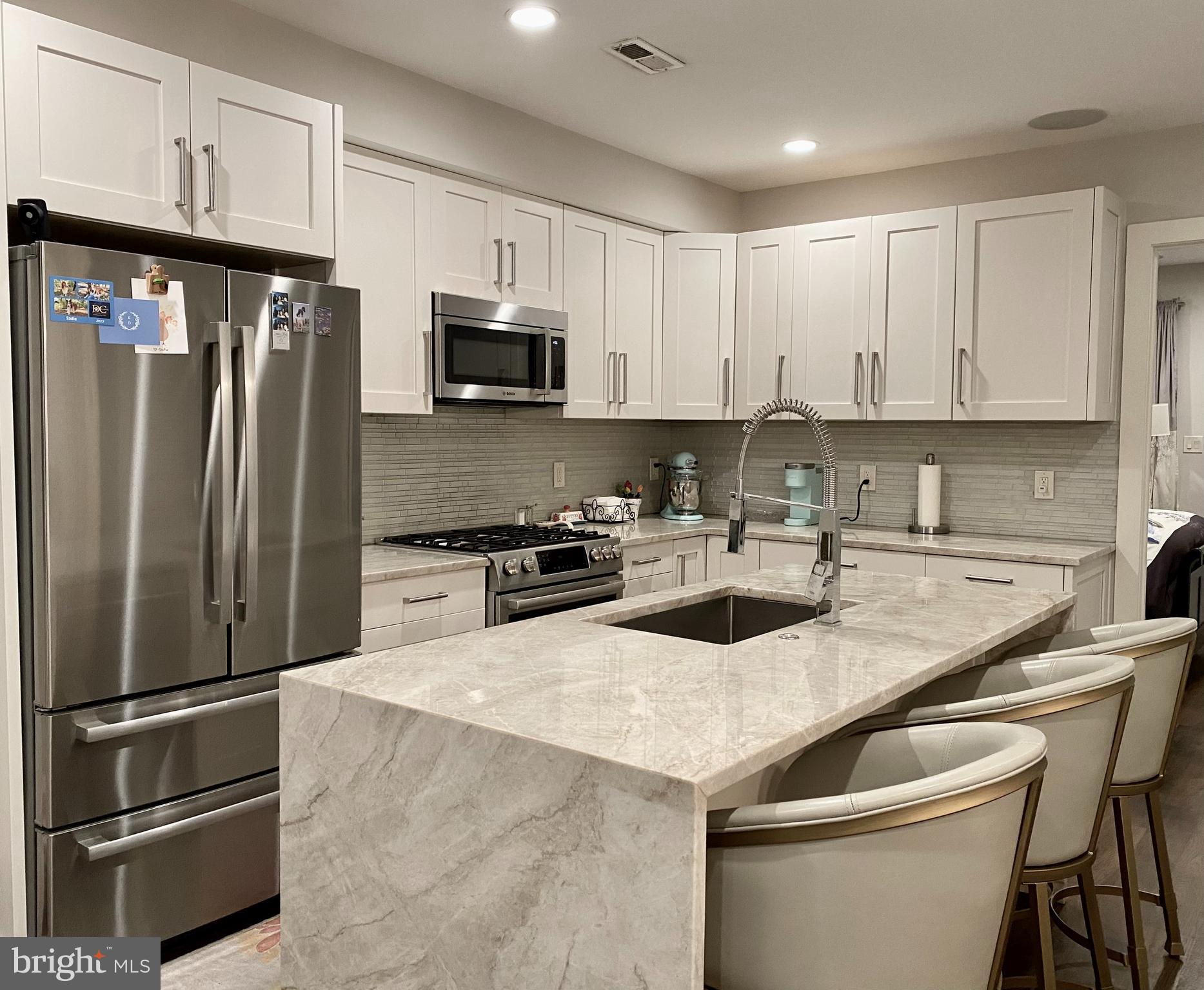 711 Jackson Street Northeast, Unit 3 Washington, DC 20017 - Photo 3 of 17 a kitchen with a sink a refrigerator and cabinets