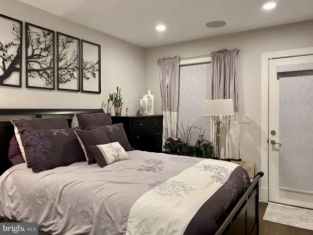 a bedroom with a large bed and wooden floor