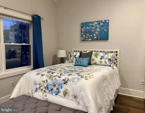 a large bed sitting in a bedroom next to a window