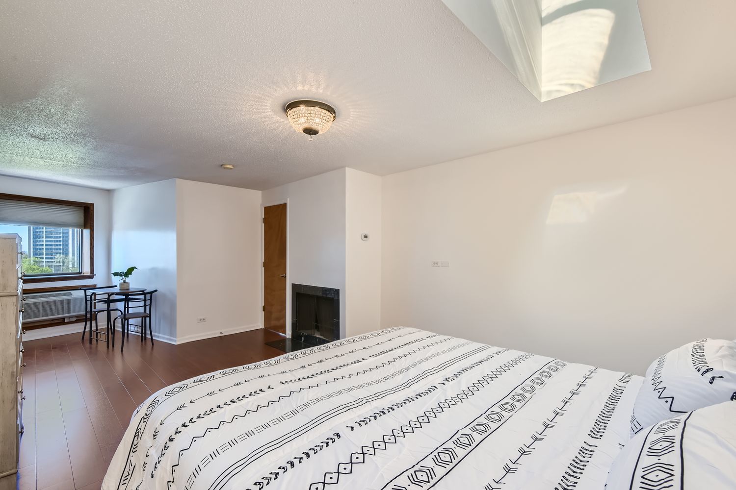 711 West Gordon Terrace, Unit 701 Chicago, IL 60613 - Photo 15 of 27 a bedroom with a bed and wooden floor