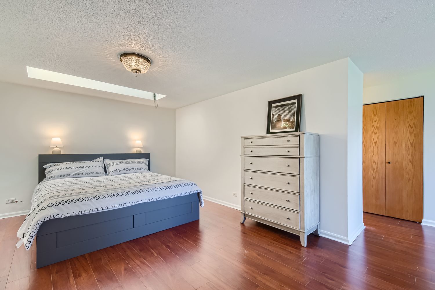711 West Gordon Terrace, Unit 701 Chicago, IL 60613 - Photo 16 of 27 a spacious bedroom with a bed and a wooden floor