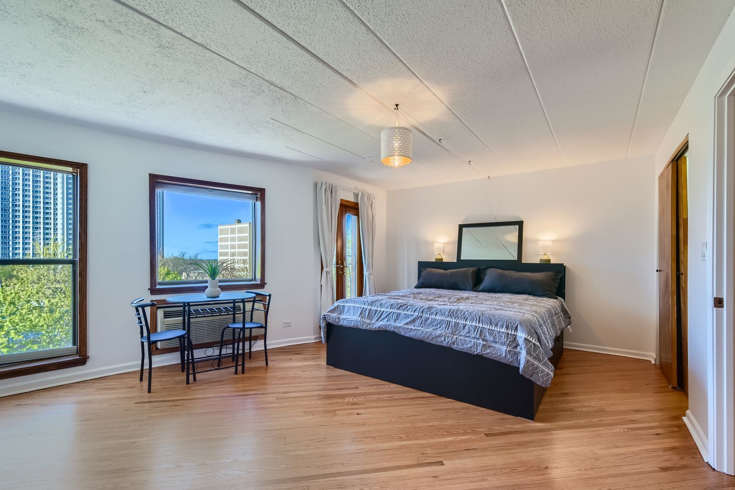 711 West Gordon Terrace, Unit 701 Chicago, IL 60613 - Photo 20 of 27 a bedroom with a bed and a table in it