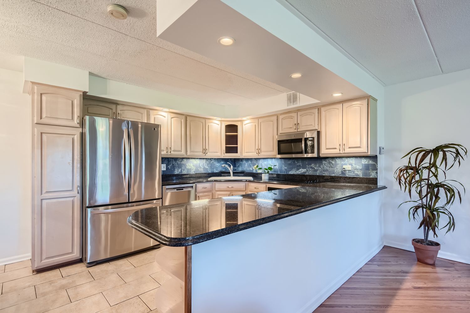 711 West Gordon Terrace, Unit 701 Chicago, IL 60613 - Photo 7 of 27 a kitchen with stainless steel appliances granite countertop a refrigerator a sink and a stove