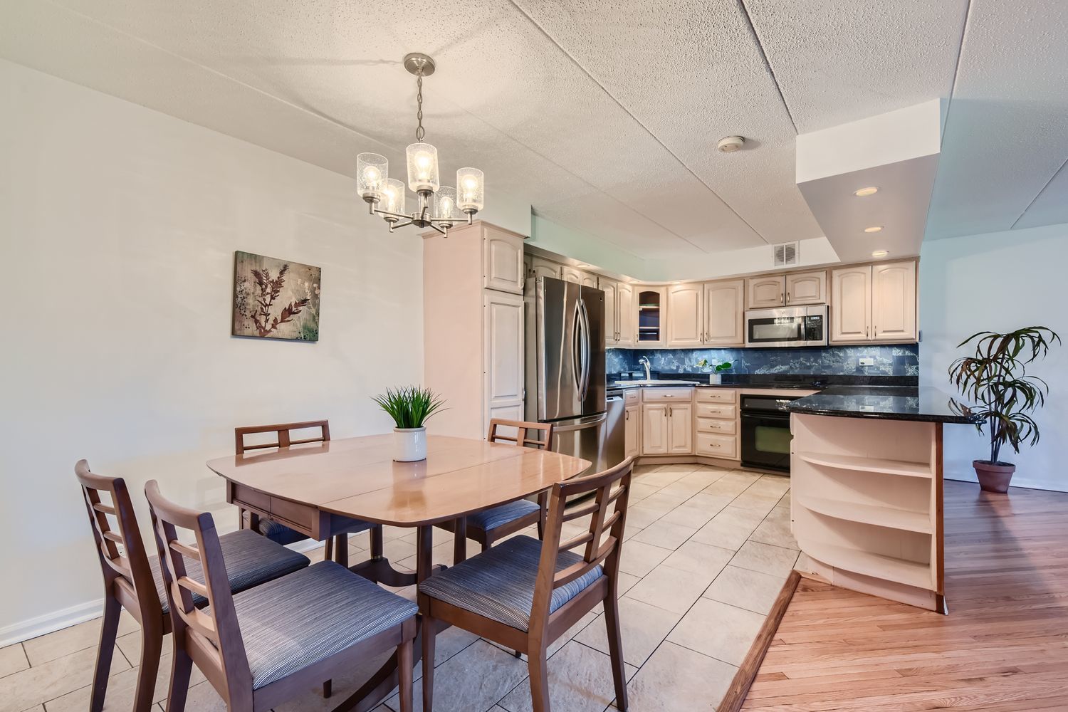 711 West Gordon Terrace, Unit 701 Chicago, IL 60613 - Photo 8 of 27 a view of a dining room with furniture wooden floor and a chandelier