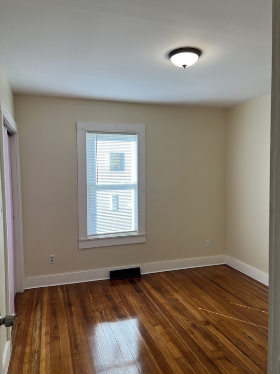 75-77 Healey Street Springfield, MA 01151 - Photo 14 of 28 an empty room with wooden floor and windows