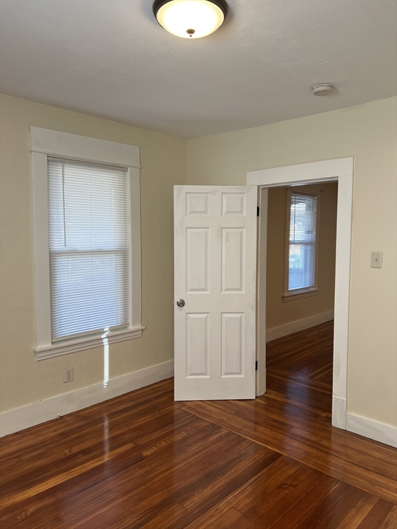 75-77 Healey Street Springfield, MA 01151 - Photo 6 of 28 an empty room with wooden floor and windows