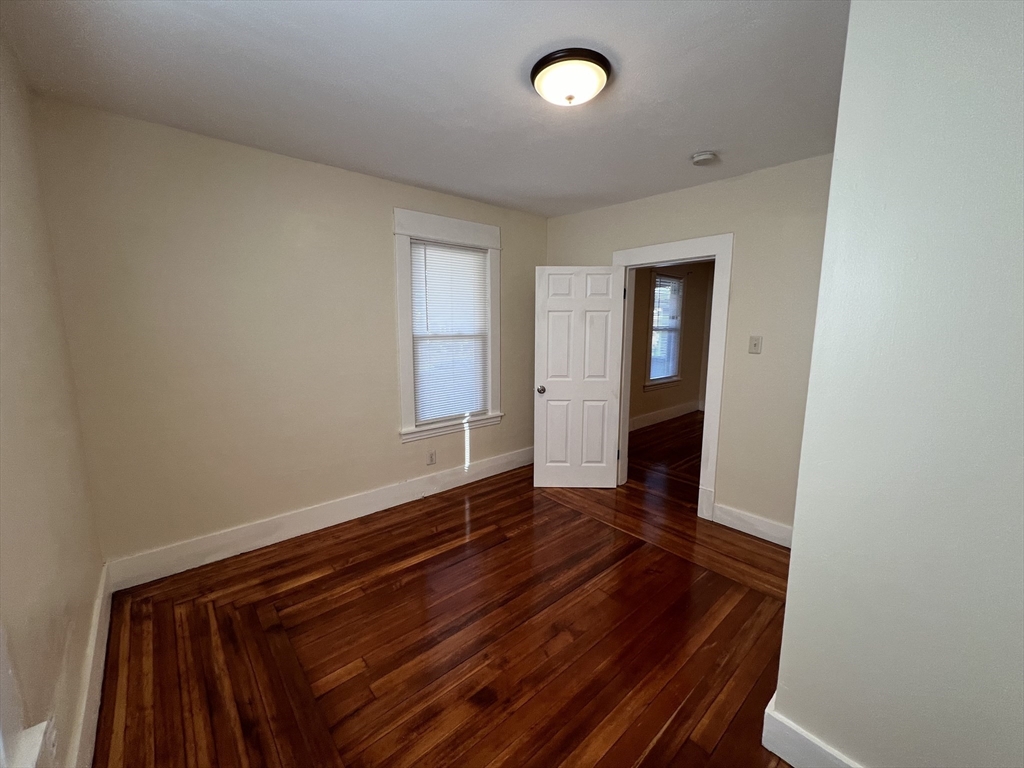 75-77 Healey Street Springfield, MA 01151 - Photo 7 of 28 an empty room with wooden floor and windows