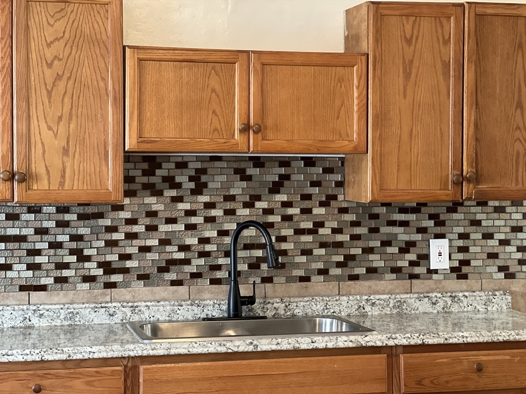 75-77 Healey Street Springfield, MA 01151 - Photo 8 of 28 a bathroom with a granite countertop sink and a mirror