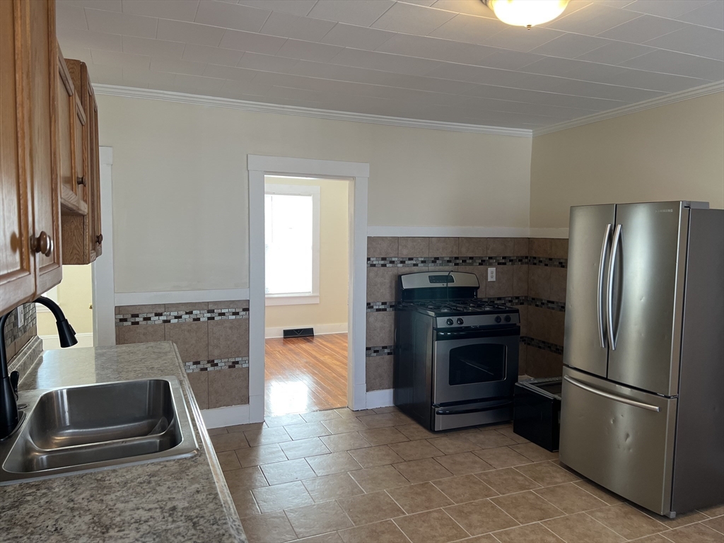 75-77 Healey Street Springfield, MA 01151 - Photo 10 of 28 a kitchen with granite countertop a refrigerator stove and sink