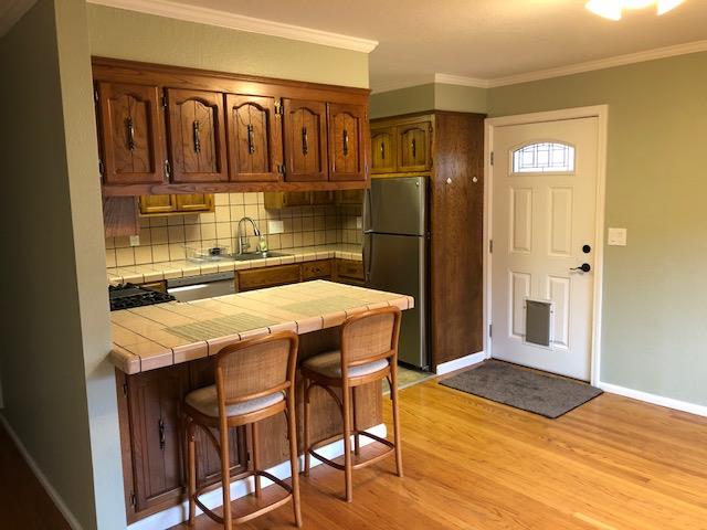 275 Kent Road, Unit B Pacifica, CA 94044 - Photo 1 of 1 a kitchen with stainless steel appliances kitchen island granite countertop a refrigerator a stove and a sink with wooden floor
