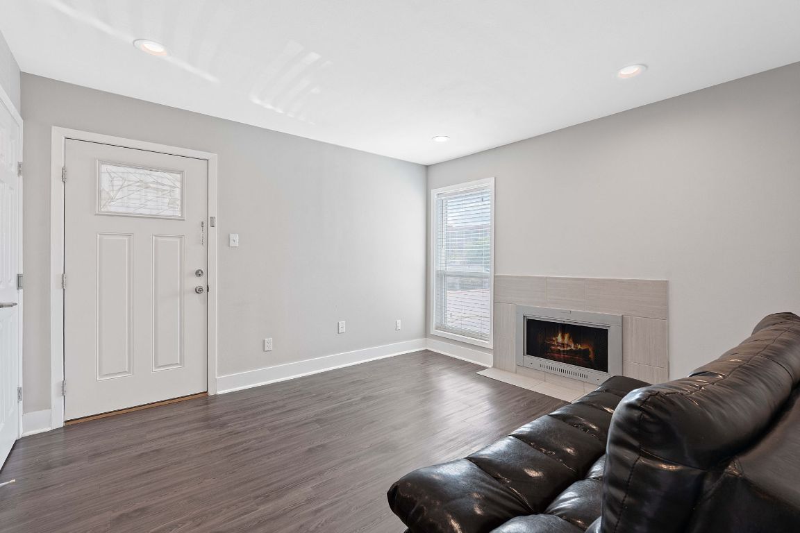 935 La Posada Drive, Unit 254 Austin, TX 78752 - Photo 6 of 19 Living room featuring a fireplace, dark wood-style flooring, and recessed lighting