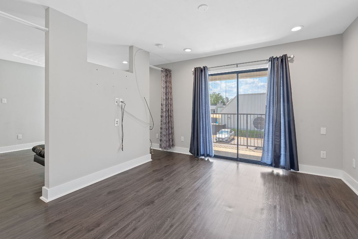 935 La Posada Drive, Unit 254 Austin, TX 78752 - Photo 9 of 19 Empty room with dark wood-style floors and recessed lighting