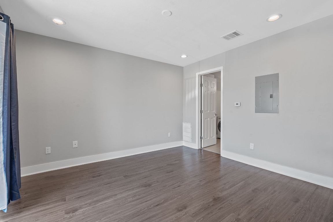 935 La Posada Drive, Unit 254 Austin, TX 78752 - Photo 10 of 19 Spare room featuring dark wood-style flooring, electric panel, and recessed lighting