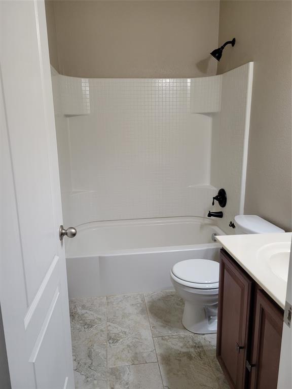 1633 Kawati Way Krum, TX 76249 - Photo 11 of 17 a white toilet sitting next to a bathroom sink and vanity