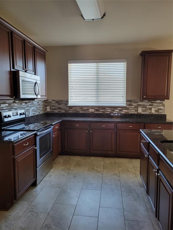 1633 Kawati Way Krum, TX 76249 - Photo 8 of 17 a kitchen with stainless steel appliances granite countertop a stove sink and cabinets