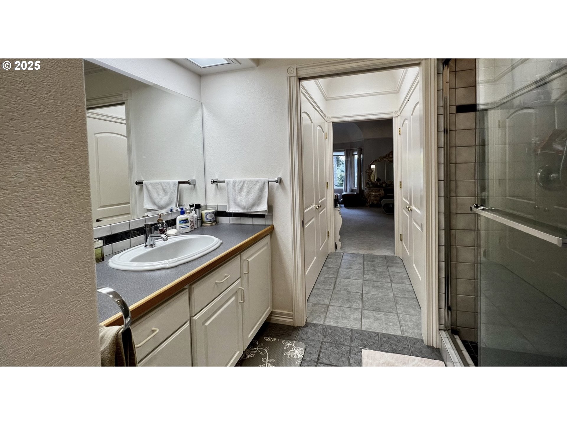 2719 Alder Ridge Drive North Bend, OR 97459 - Photo 26 of 27 a bathroom with a sink a mirror and a shower