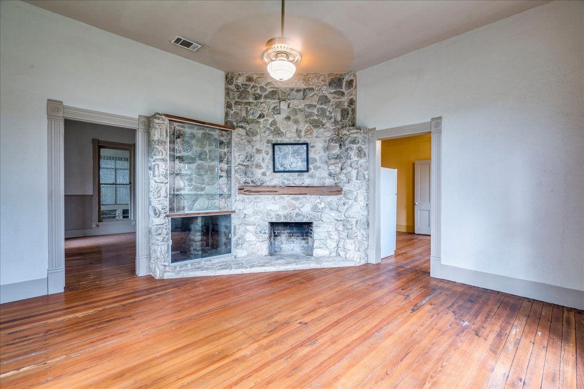 6400 Cypress Road Kyle, TX 78640 - Photo 12 of 33 Stone-clad corner fireplace with an integrated display cabinet and a wood mantel