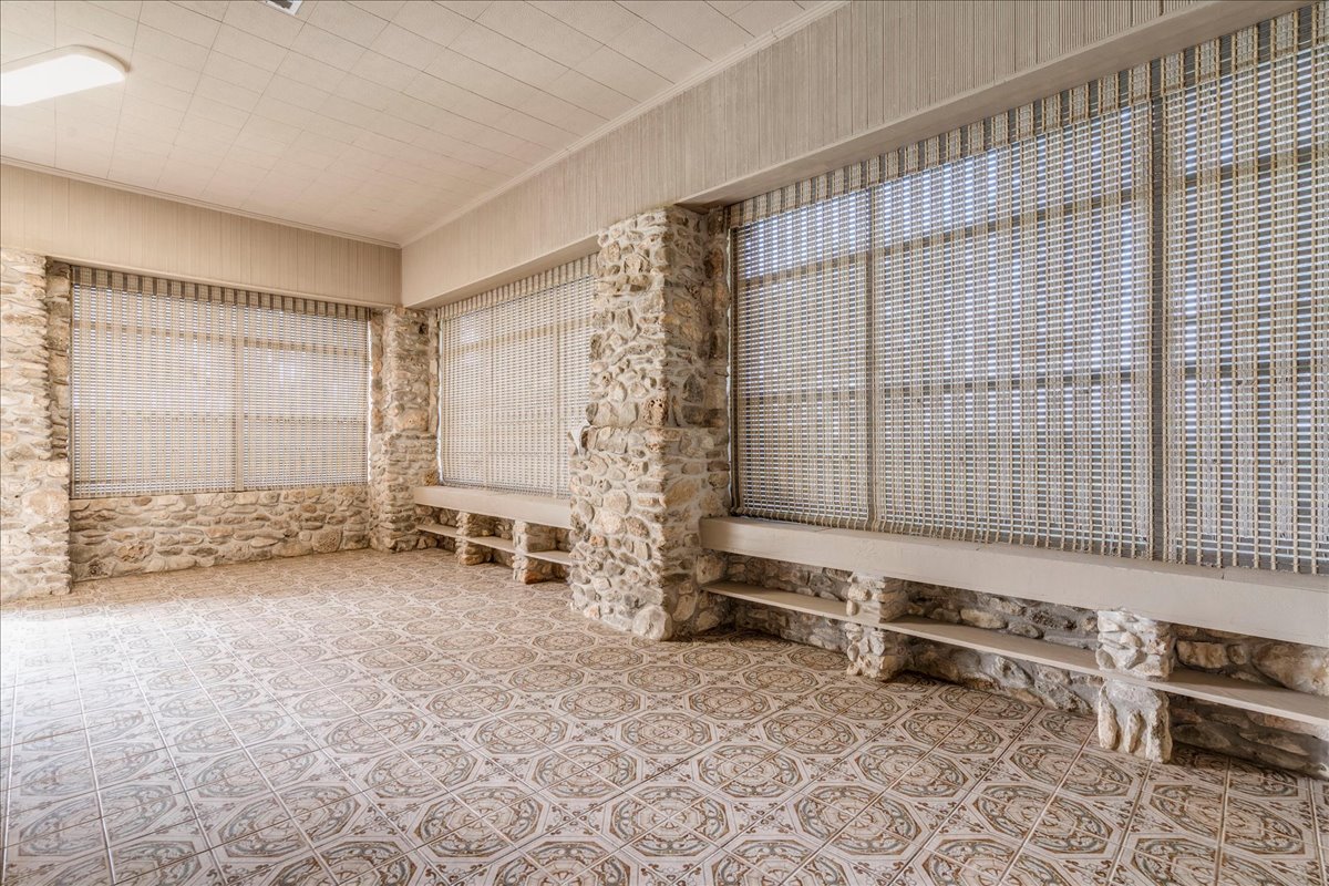 6400 Cypress Road Kyle, TX 78640 - Photo 16 of 33 Stone-clad walls defining an expansive room featuring patterned floor tiles
