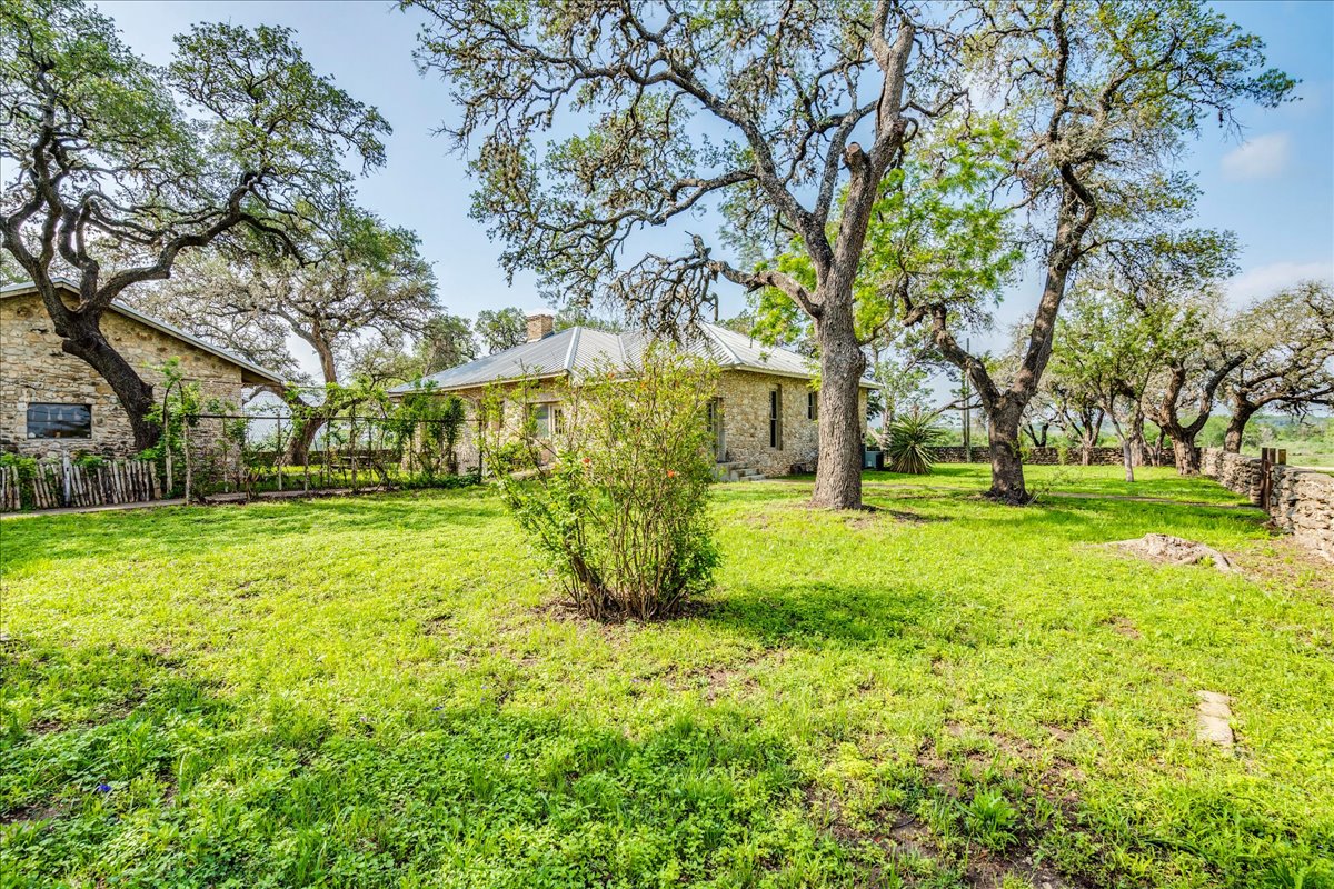 6400 Cypress Road Kyle, TX 78640 - Photo 2 of 33 Expansive green lawn with mature trees and stone perimeter wall