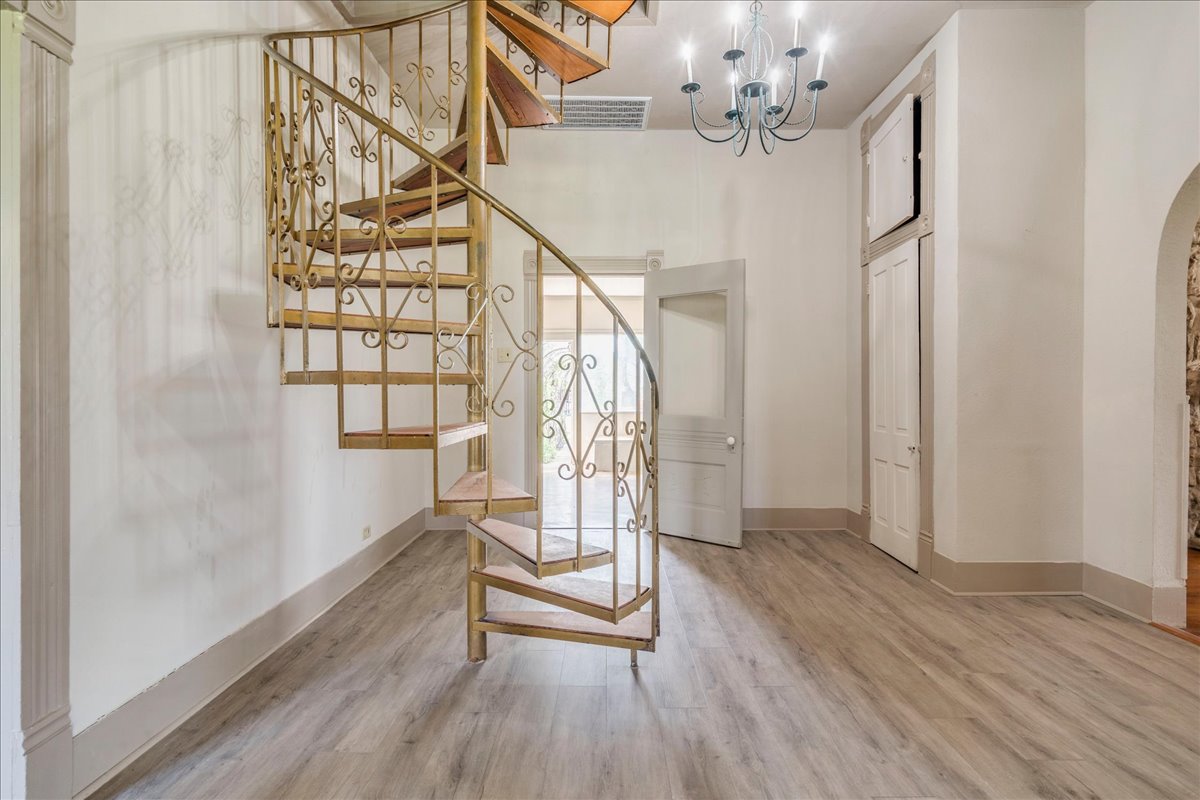 6400 Cypress Road Kyle, TX 78640 - Photo 25 of 33 Ornate spiral staircase with gilded wrought iron railings and wood-finish treads