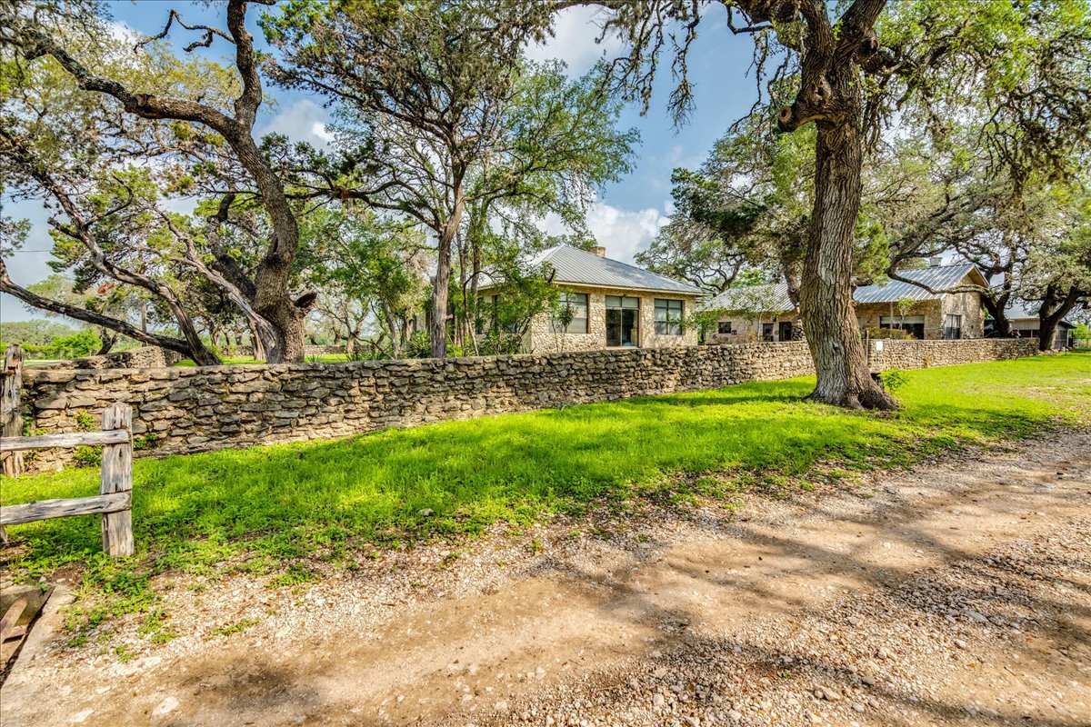 6400 Cypress Road Kyle, TX 78640 - Photo 5 of 33 Stone exterior residence with a metal roof and prominent stone wall