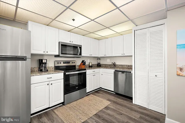 a kitchen with a refrigerator a stove top oven a sink and cabinets