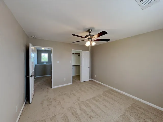 a view of an empty room with closet and chandelier fan